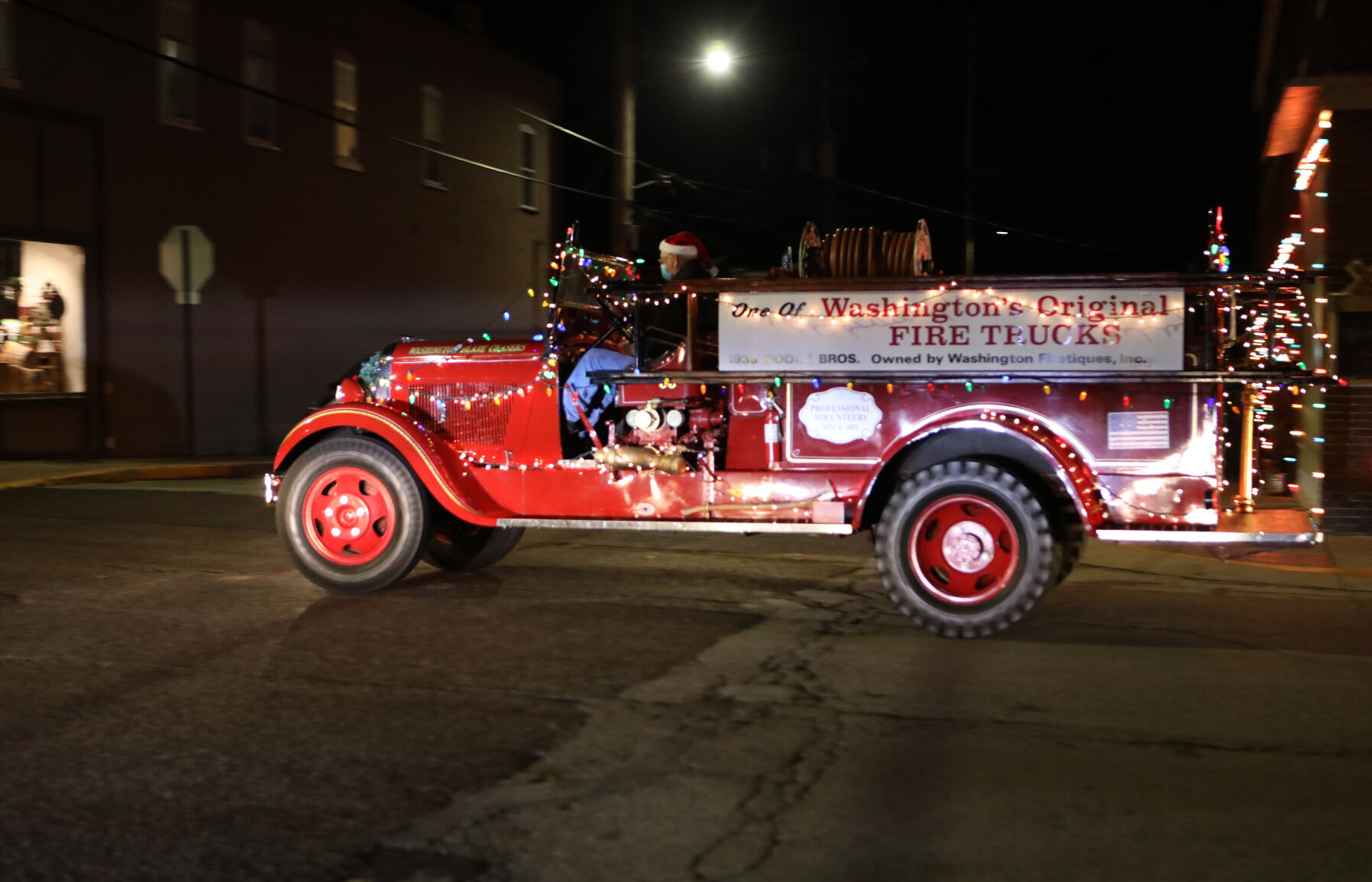 An antique firetruck is driven along Elm Street